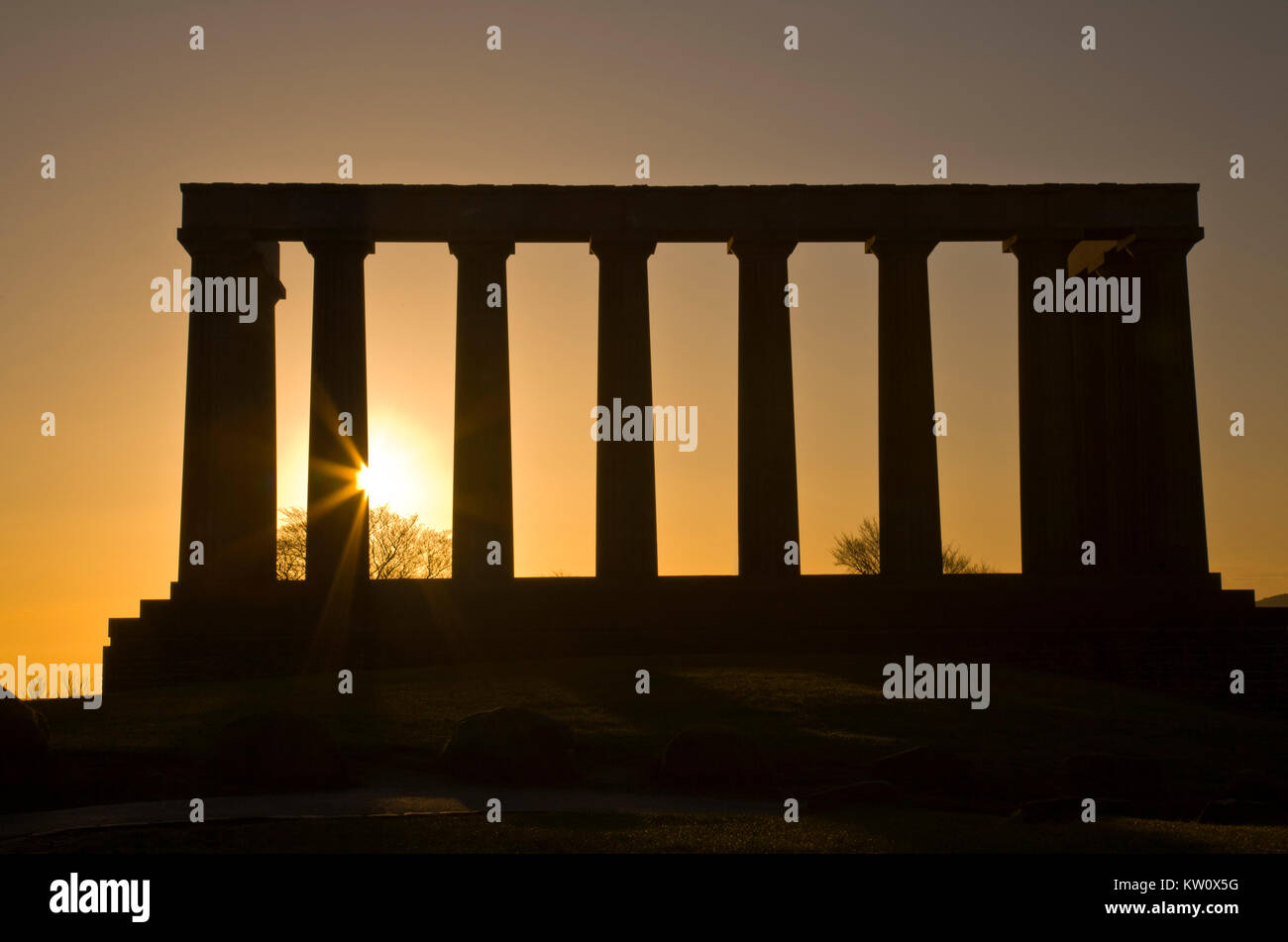 Rising Sun Fackeln durch die Spalten der nationalen Denkmal in Edinburgh, Schottland Stockfoto