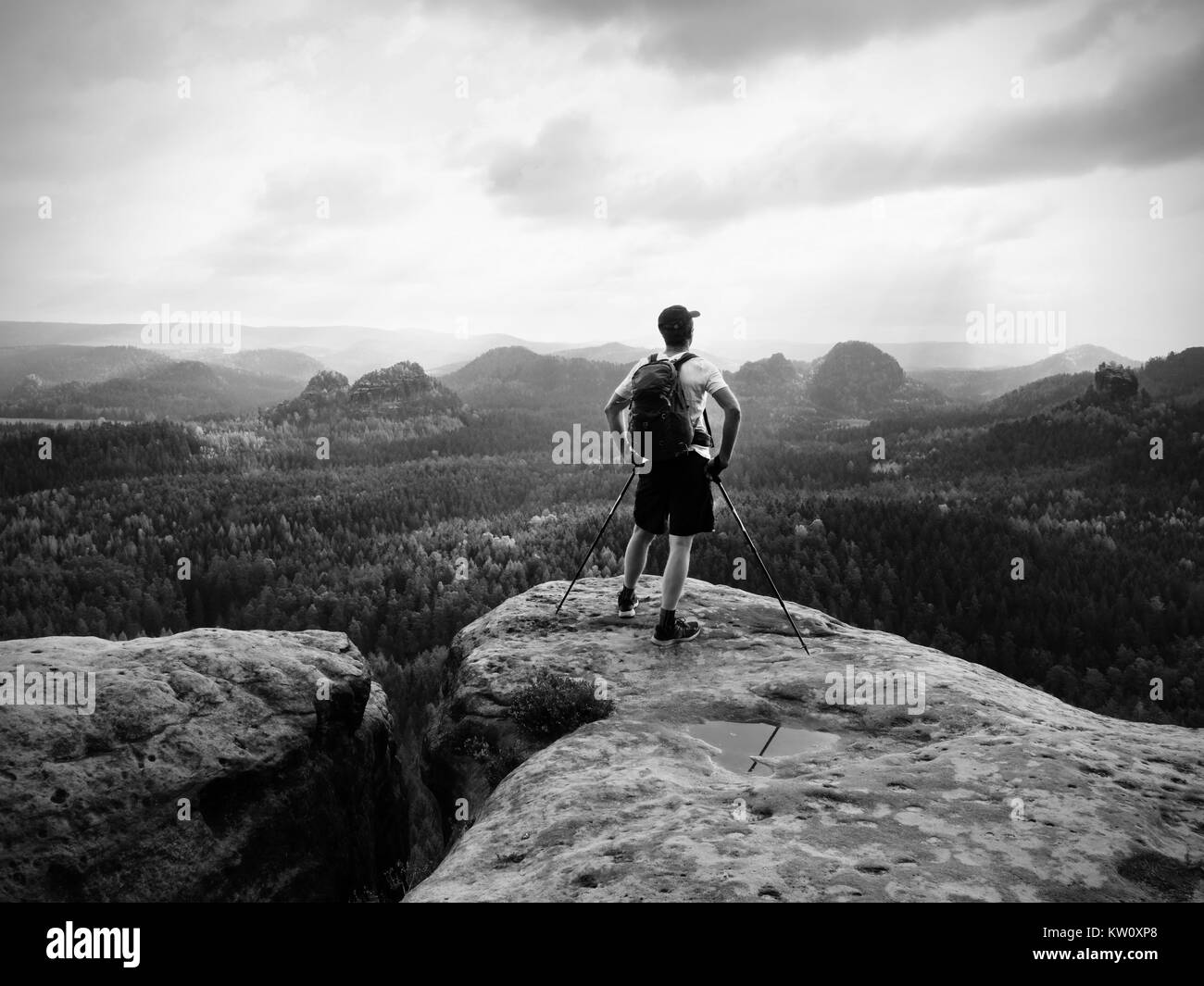 Reiseführer auf Rocky View Point mit Stöcken in der Hand. Wanderer mit Sportlicher Rucksack stand auf Rocky View Point über neblige Tal. Sonnige Frühling daybreak i Stockfoto