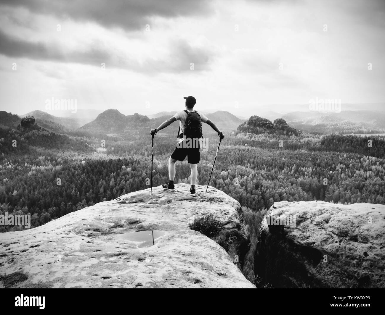 Reiseführer auf Rocky View Point mit Stöcken in der Hand. Wanderer mit Sportlicher Rucksack stand auf Rocky View Point über neblige Tal. Sonnige Frühling daybreak i Stockfoto