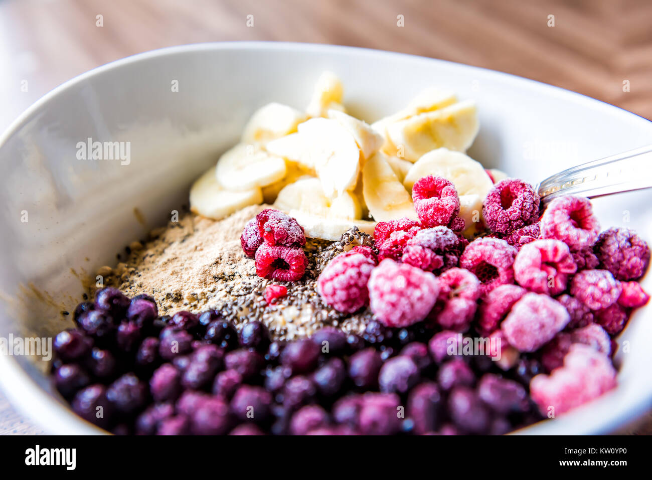 Gefrorene Heidelbeeren, Himbeeren, Banane, Maca und Chia Samen Belag auf haferflockenbrei Stockfoto