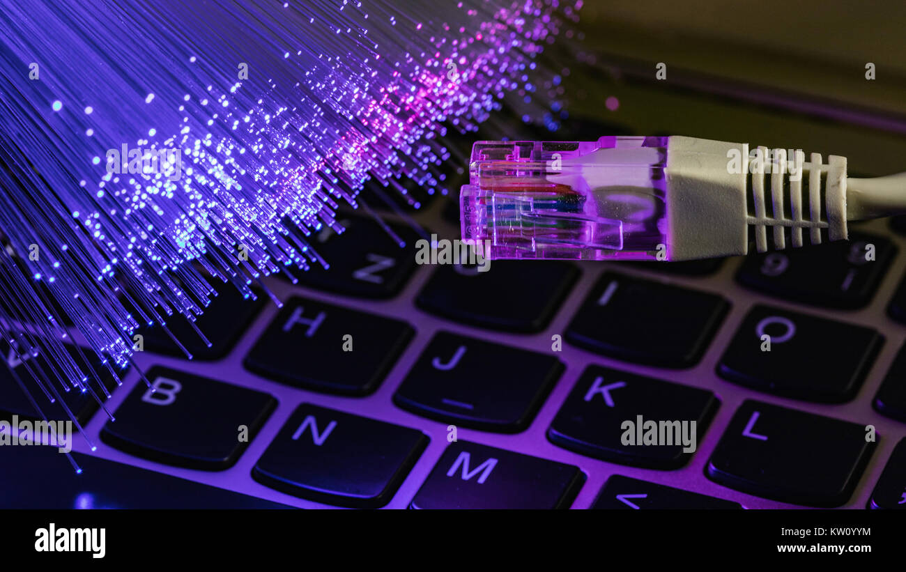 Netzwerkkabel closeup mit LWL-Hintergrund, Farbe LWL-Hintergrund mit notebookk, Fiberoptik Licht abstrakt Hintergrund Stockfoto