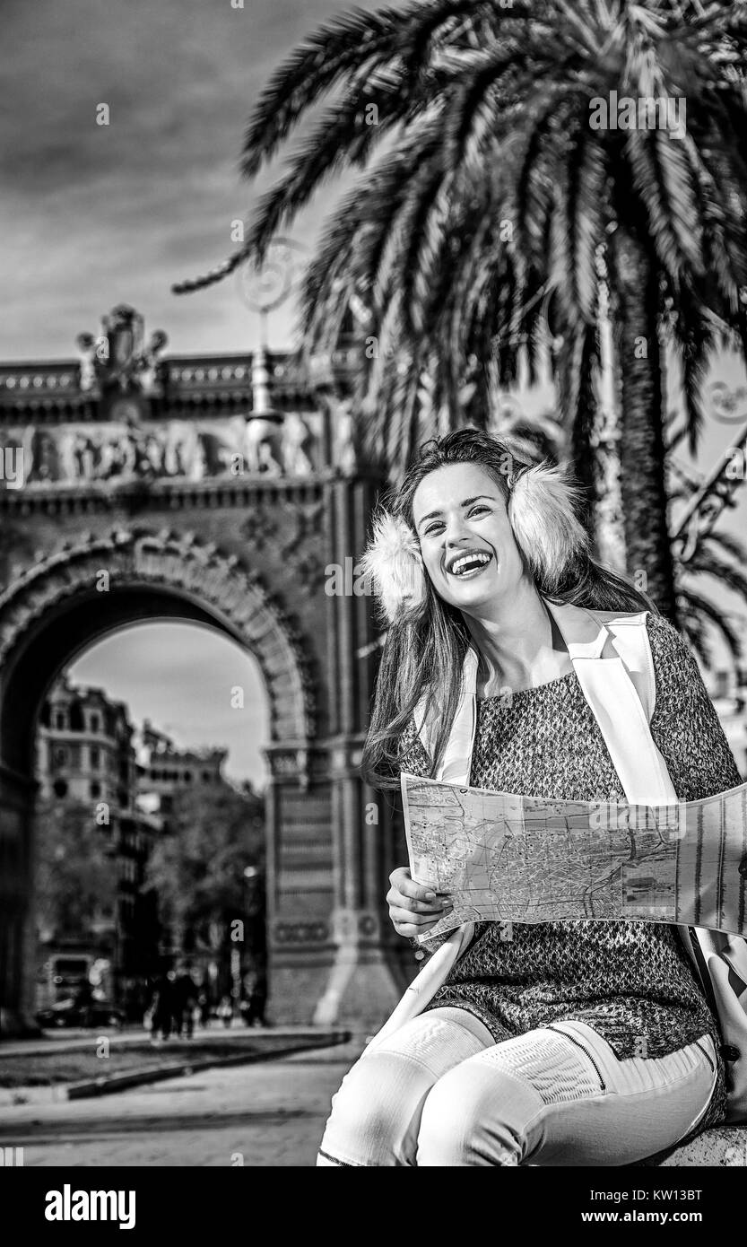 in Barcelona für einen perfekten Winter. lächelnd modernen Mode-Monger in Ohrenschützer in der Nähe von Arc de Triomf in Barcelona, Spanien mit Blick in die Ferne Karte Stockfoto