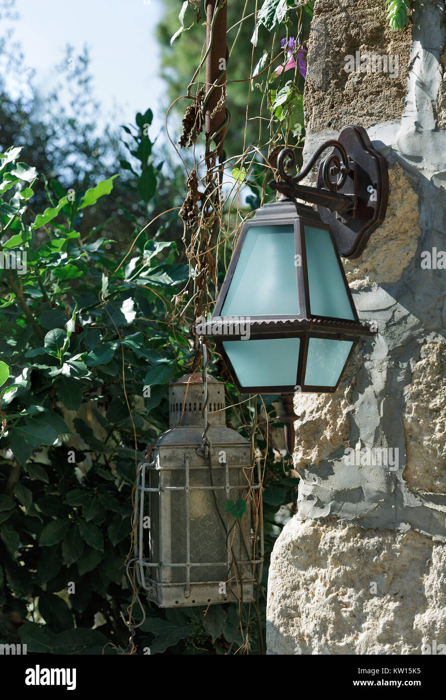 Alte Lampen hängen an der Mauer aus Stein Stockfoto