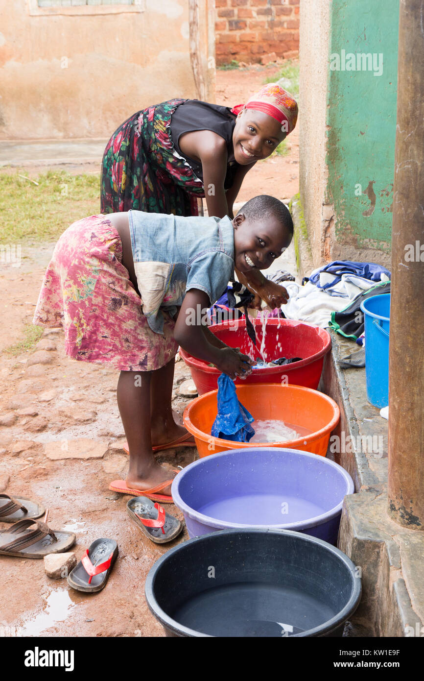 Lugazi, Uganda. Juni 09 2017. Junge afrikanische Mädchen Wäsche waschen bei Waschbecken vor einem Haus. Stockfoto