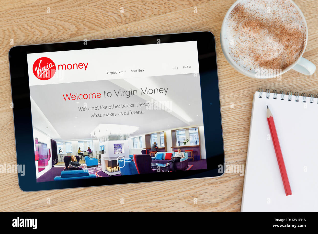 Die Virgin Money Website auf einem iPad Tablet Gerät, das auf einem Tisch liegt neben einem Notizblock und Bleistift und eine Tasse Kaffee (nur redaktionell) Stockfoto