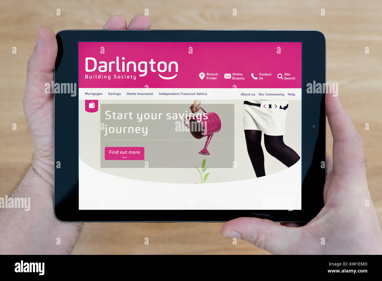 Ein Mann sieht das Darlington Building Society Website auf seinem iPad tablet device, Schuß gegen einen hölzernen Tisch top Hintergrund (nur redaktionelle Nutzung) Stockfoto
