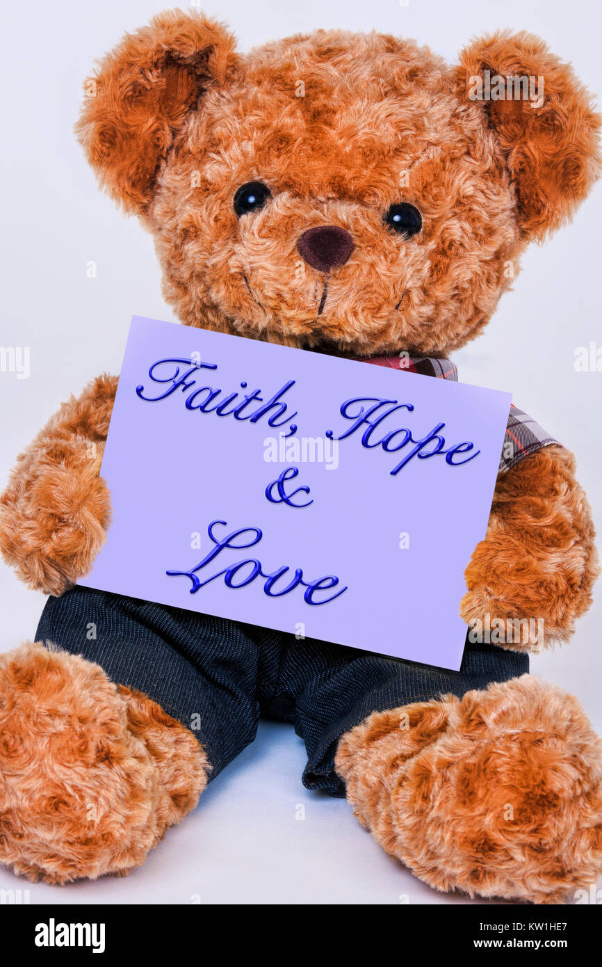 Cute teddy bear Holding ein violettes Schild mit der Aufschrift Glaube, Hoffnung und Liebe auf weißem Hintergrund Stockfoto