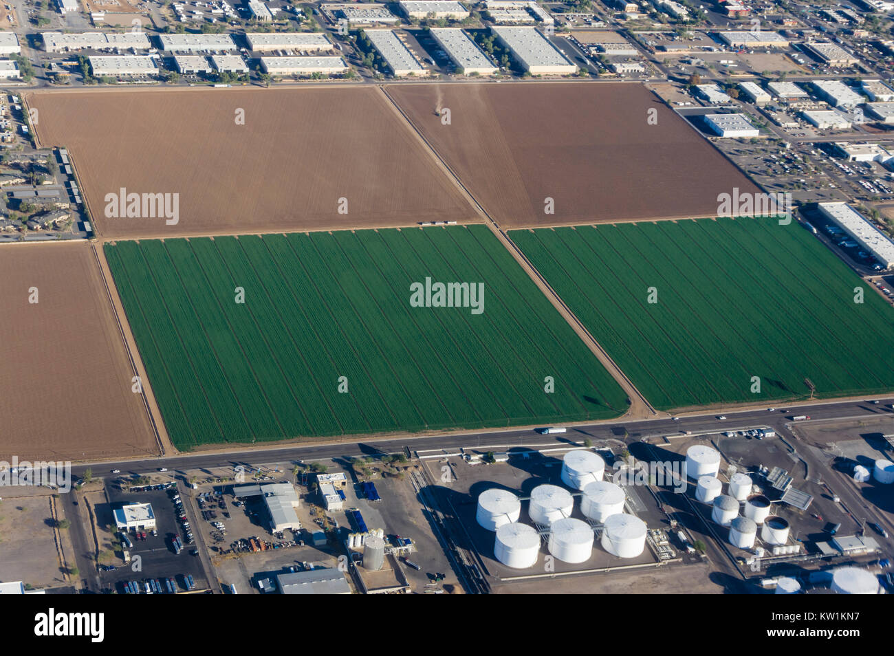 Luftaufnahme von landwirtschaftlichen Flächen durch Industrie- und Wohnungsbau umgeben Stockfoto