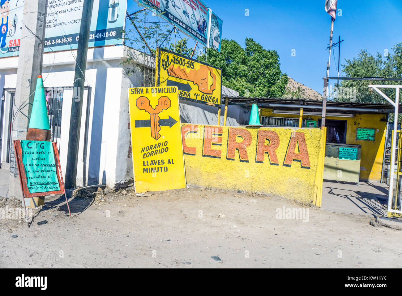 Mehrere helle Buntes Aufmerksamkeit erhalten Zeichen informieren Passanten Treiber zu kleinen Mexikanischen Schlosserei neben State Highway 15. Stockfoto