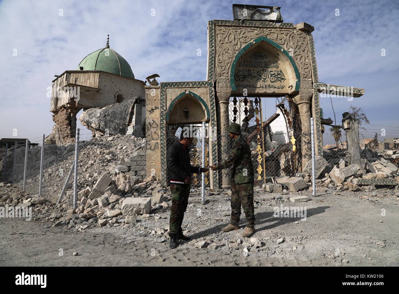 (171229) - MOSSUL (Irak), Dez. 29, 2017 (Xinhua) - Irakische Soldaten sprechen außerhalb der beschädigten al-Nuri Moschee in der Altstadt von Western Mosul, Irak, Dez. 29, 2017. Wiederaufbau der Alten Stadt in Western Mosul ist unter langsam voran. Rund sechs Monate nach dem vollständigen Befreiung von Mosul, die alte Stadt in Western Mosul liegt noch in Trümmern, und nur wenige haben die Bewohner nach Hause zurück. Die wichtigsten Straßen haben in diesem Bereich geräumt worden, aber eine große Anzahl von engen Gassen sind noch durch die eingestürzten Häuser abgedeckt. Am 10. Juli, der irakische Ministerpräsident Haider al-Abadi förmlich erklärt volle Befreiung von Mosul, Stockfoto