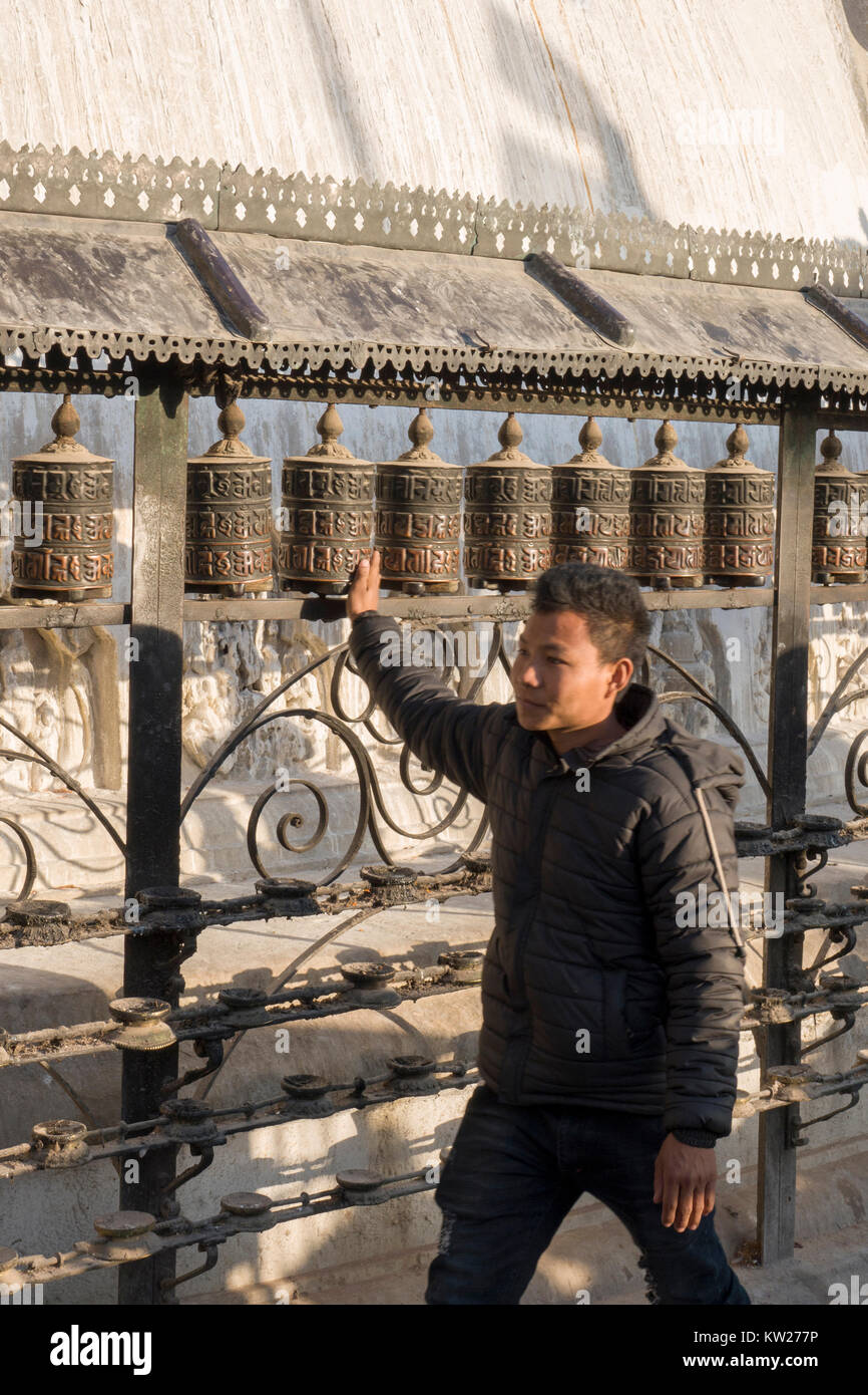 Man spinnen Gebetsmühlen an Swayambhunath Tempel, Kathmandu, Nepal Stockfoto