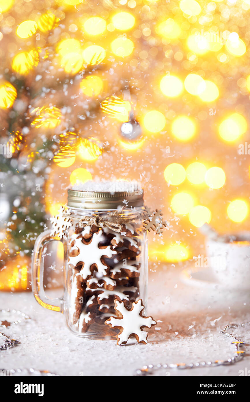 Lebkuchen Sterne im Glas auf weißen Tisch golden bokeh Hintergrund mit Schnee herum. Stockfoto