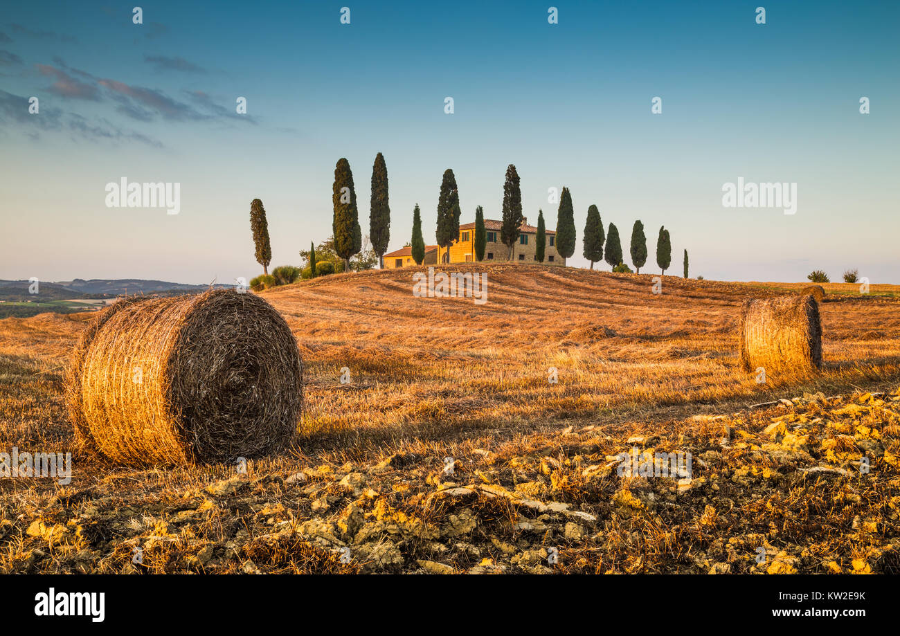 Wunderschöne Toskana Landschaft mit traditionellen Bauernhof Haus und Heuballen im goldenen Abendlicht, Val d ' Orcia, Italien Stockfoto