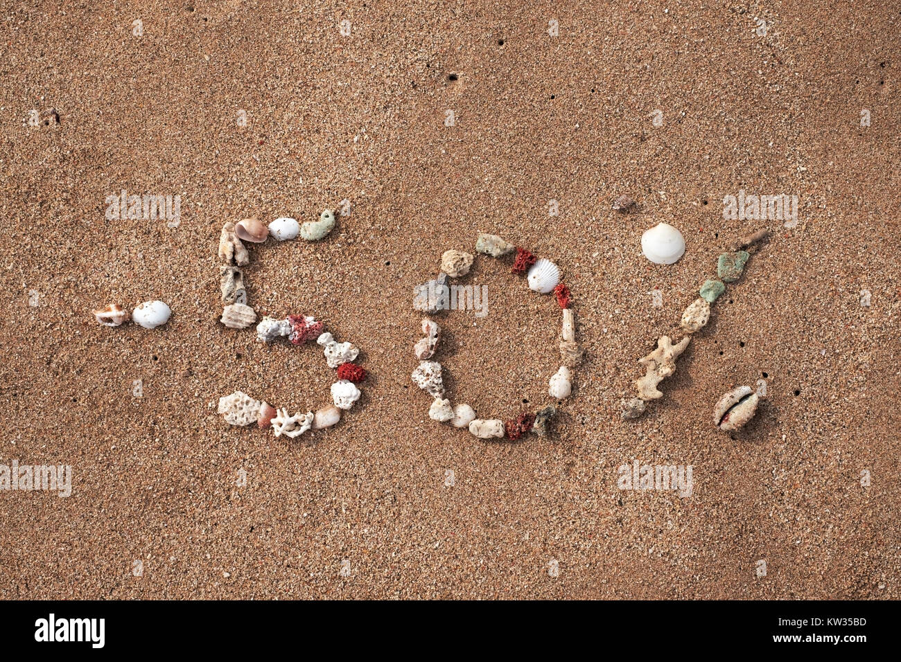 Text 50 Prozente auf Sand von Shell am Meeresufer. Konzept für grosse Verkäufe oder schwarzer Freitag Stockfoto