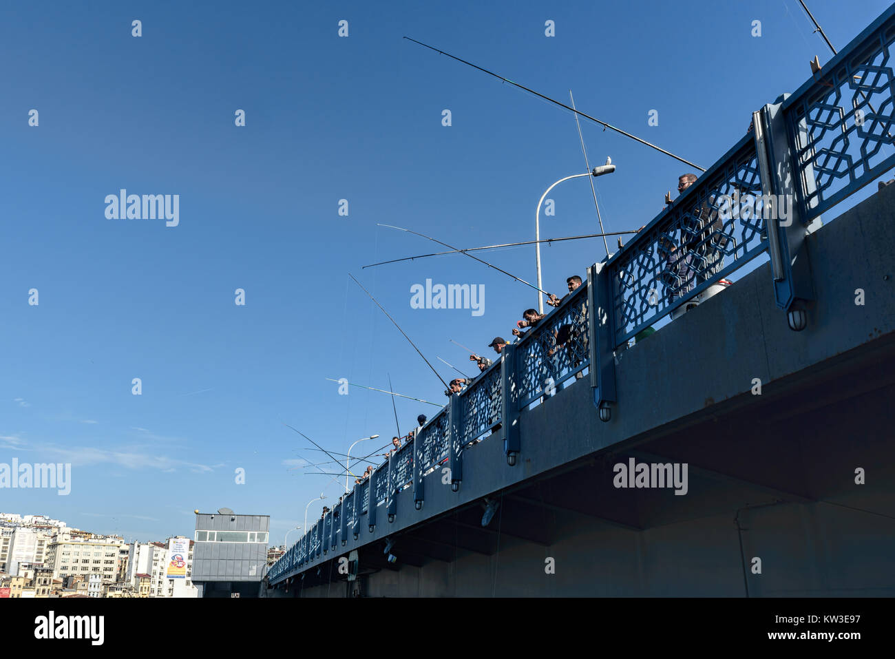 Fischer auf einer Brücke unter azurblauem Himmel Stockfoto