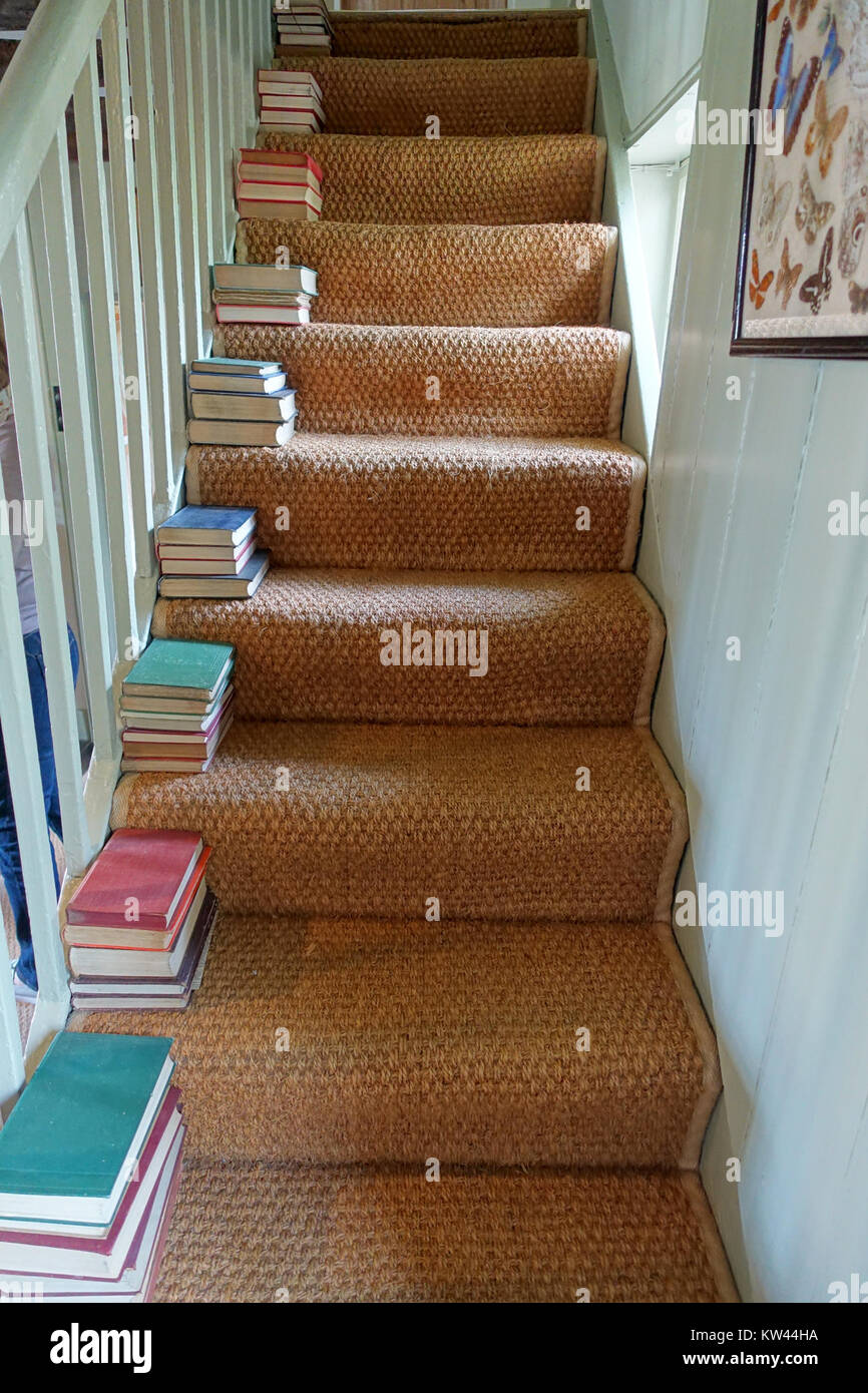 Das Foto zeigt eine Ansicht von Büchern auf einer Treppe im Monk's House in Rodmell, East Sussex, England. Dieses Haus war die ehemalige Residenz der Schriftstellerin Virginia Woolf. Stockfoto