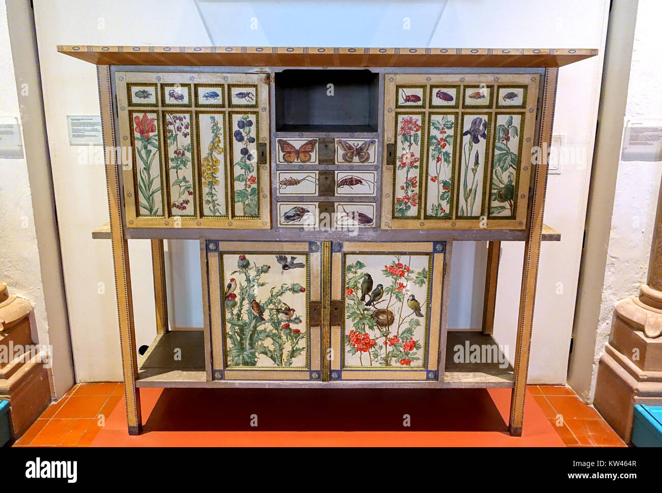 Fotografie eines Bücherregals mit Gemälden von Wilhelm Rinneberg, 1905 mit bemalten Fichten- und Messingbeschlägen, untergebracht im Germanischen Nationalmuseum in Nürnberg. Stockfoto