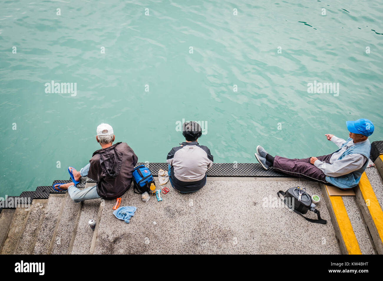 Chinesische Männer angeln an einem Pier in Hong Kong Stanley Stockfoto
