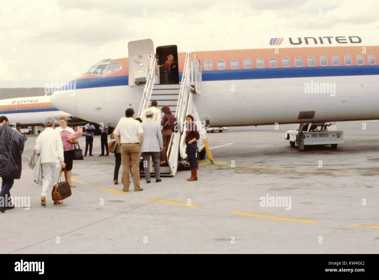 Reisende an Bord eines United Airlines Jet mit boarding Treppen, 1975. Stockfoto