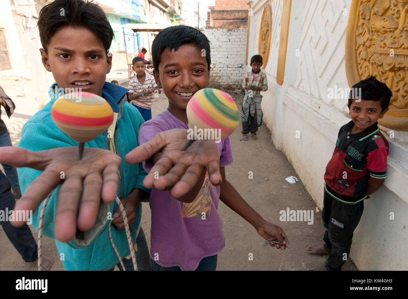 Indien. Bihar. Bodhgaya. Jungen spielen mit einfachen Kreisel Stockfoto