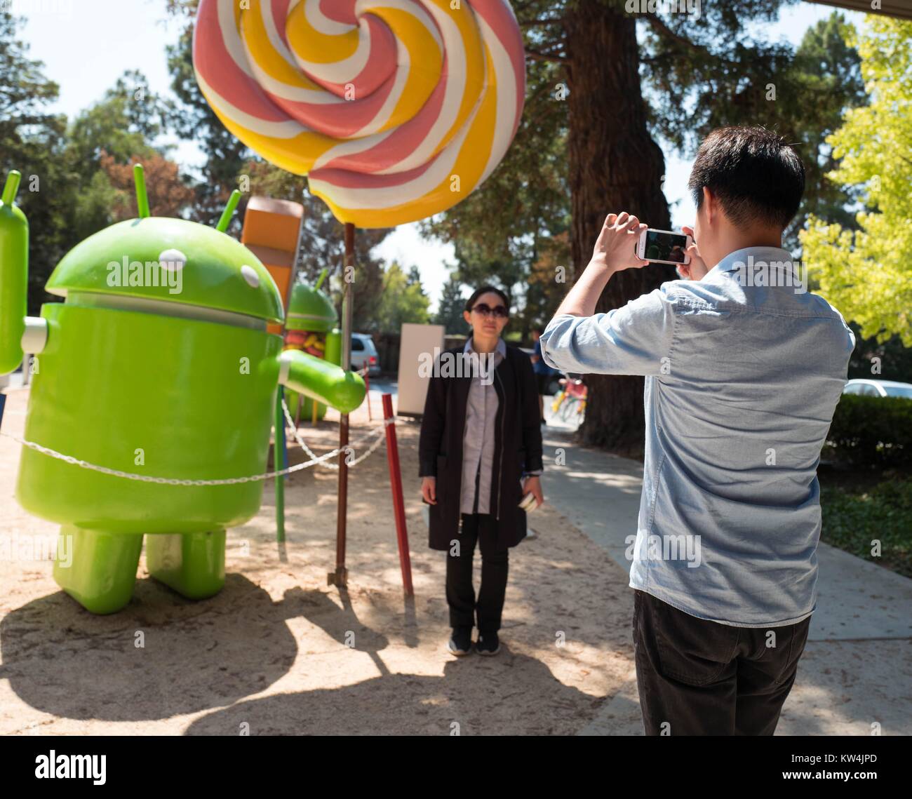 Im Googleplex, dem Sitz der Firma Google Search Engine im Silicon Valley Stadt Mountain View, Kalifornien, Touristen fotografieren mit einer Statue, die die Android Handy Betriebssystem, Mountain View, Kalifornien, 24. August 2016. Stockfoto