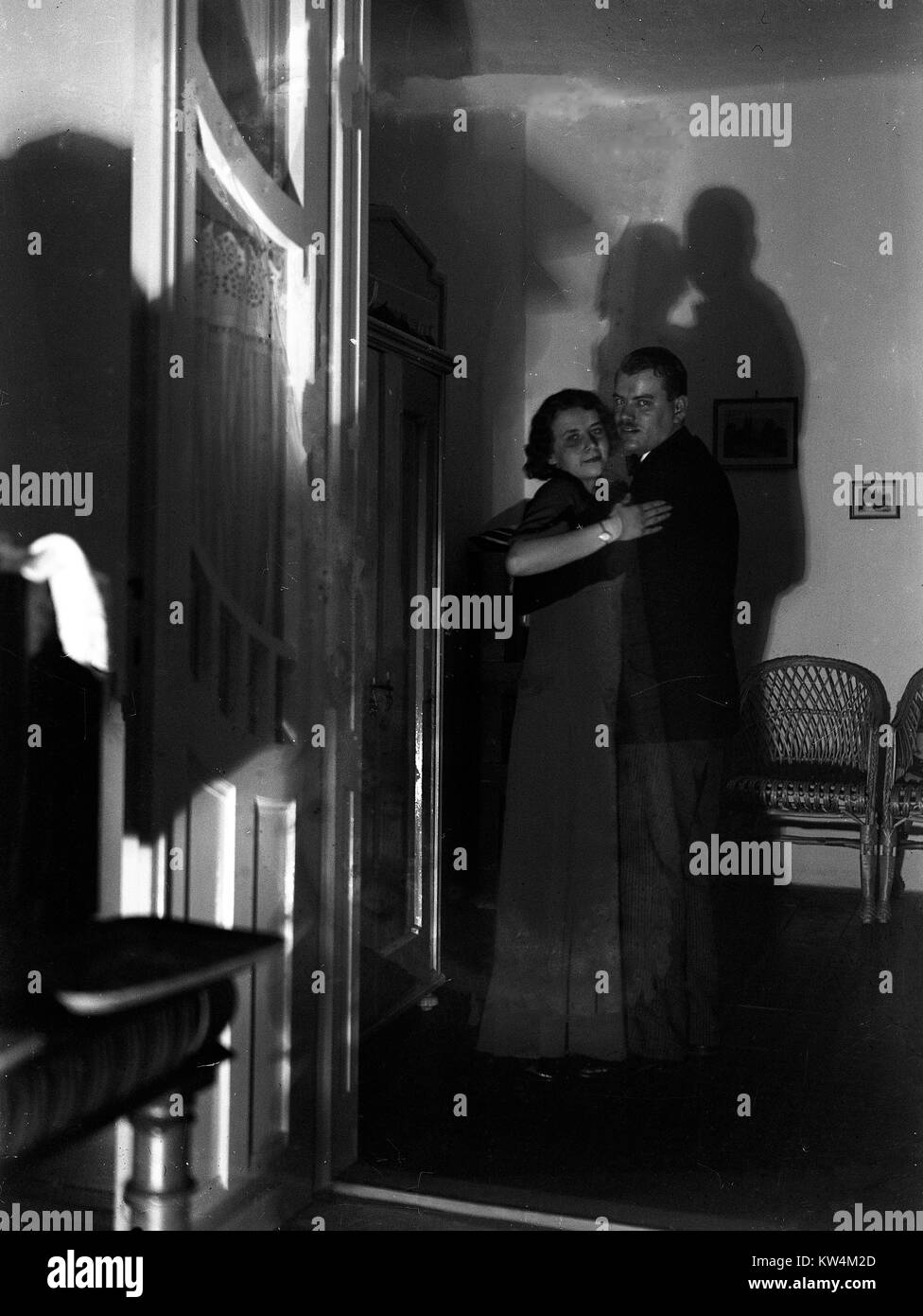 In einem dunklen, stark beleuchteten Raum, ein paar Tänze in der Mitte mit ihren Schatten auf die Wand hinter Ihnen, Ungarn, 1929. Von einem Gelatine Prozess Glasplatte negative digitalisiert, mit einigen Beschädigungen auf dem ursprünglichen Negativen vorhanden. Stockfoto