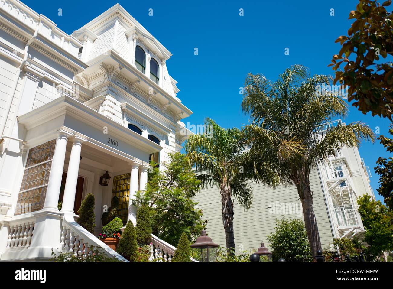 Elegante weiße Villa im viktorianischen Stil mit Palmen, an einem sonnigen Tag in der Cow Hollow Viertel von San Francisco, Kalifornien, 28. August 2016. Stockfoto
