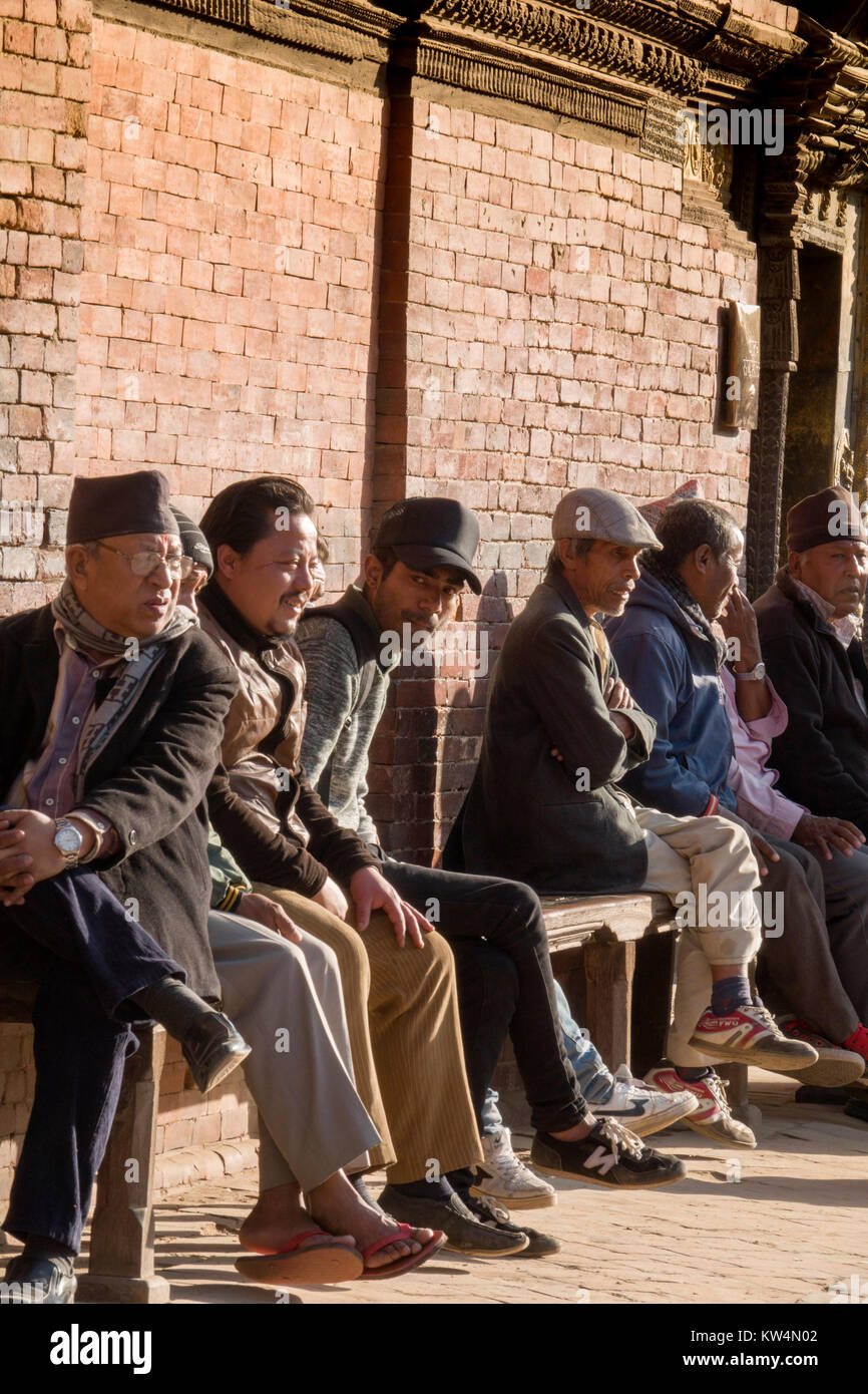 Sit-Gruppe der Nepalesischen Männer, die in der Sonne an Patan Durbar Square, Kathmandu Stockfoto