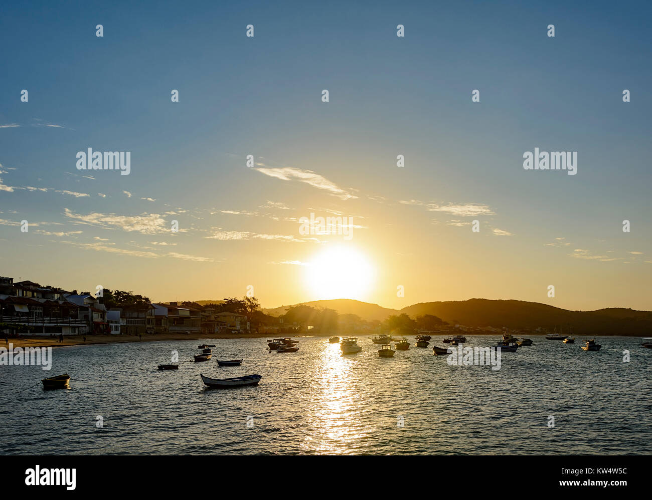 Fischerboote am Meer und Bauten, die das Meer bei Sonnenuntergang in der Stadt Buzios im Sommer Stockfoto