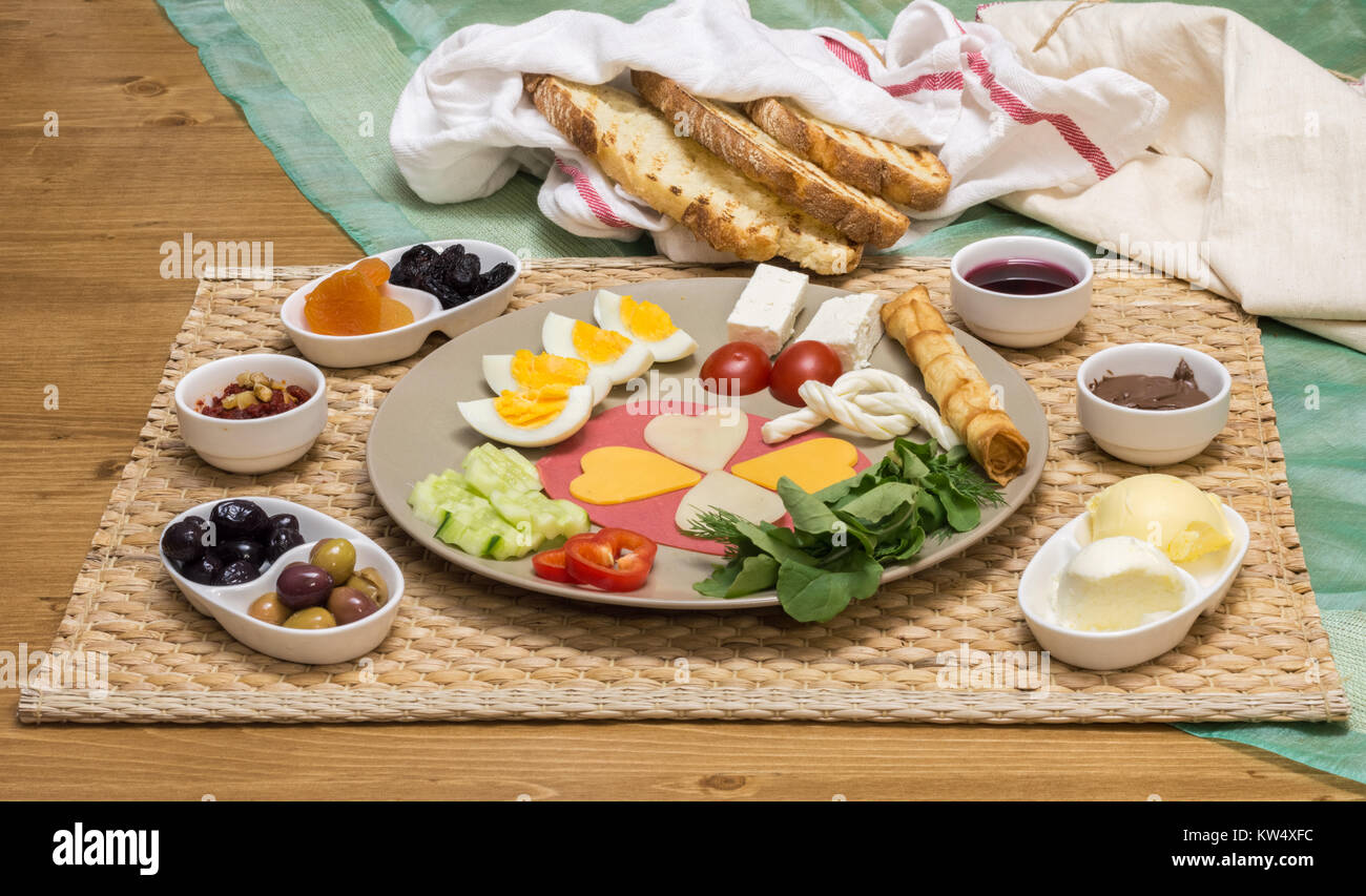 In der Nähe der traditionellen türkischen Frühstück serviert auf Porzellan Teller mit Käse, Salami, gekochtem Ei, Tomaten, Gurken und geröstetem Brot Stockfotografie
