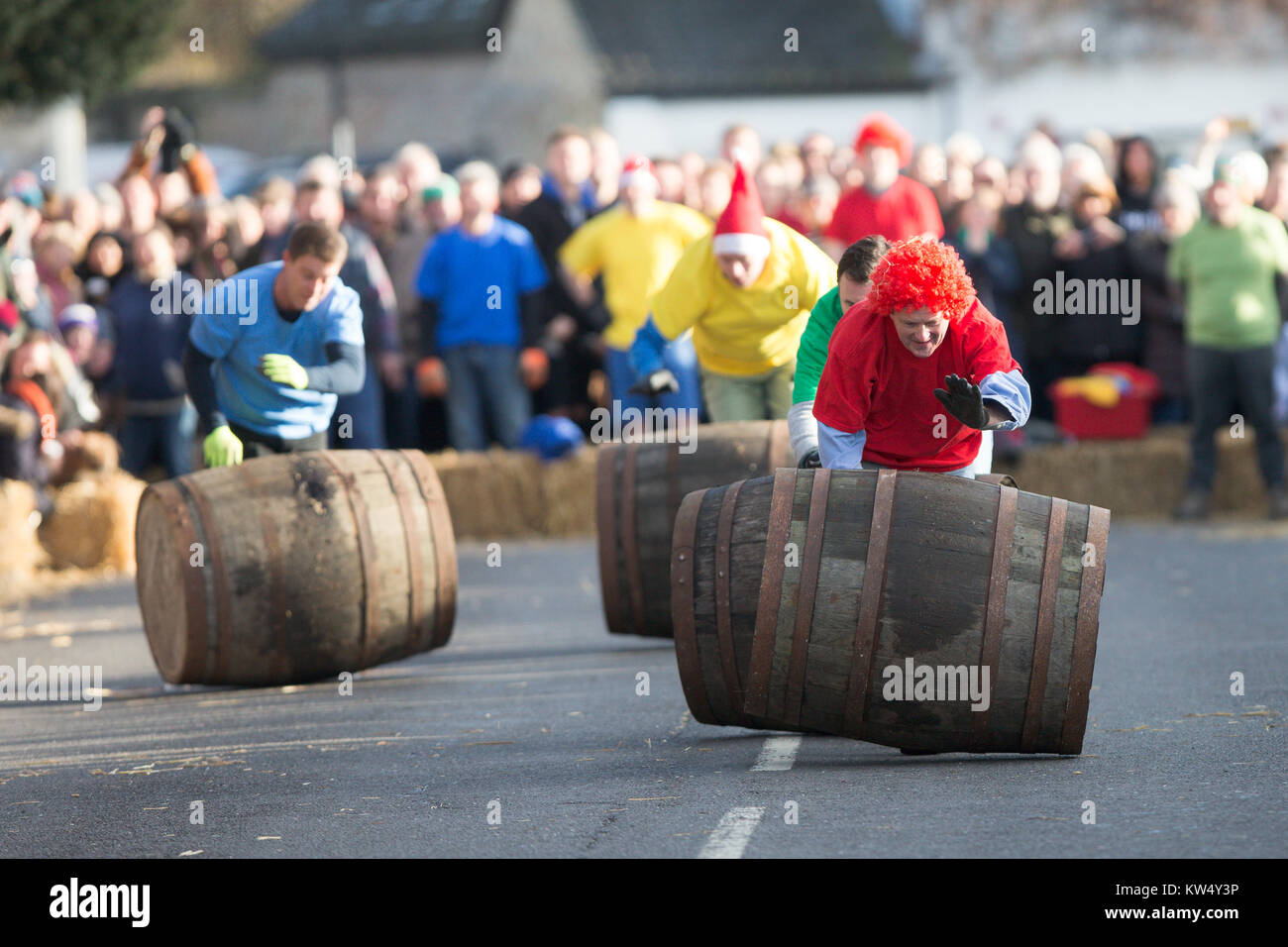 Bild zeigt Konkurrenten versuchen, ihren Lauf in den jährlichen Boxing Day Barrel Race im Dorf Grantchester in der Nähe von Cambridge zu steuern. (Dec 26) Teams aus den vier lokalen Pubs konkurrieren, in der Regel vier in einer Zeit der leeren Fässer bis die Straße so schnell wie möglich zurückzufahren, ohne zu verletzen die Massen der Zuschauer, die Gefahr für Leib und Leben während Schreien Ermutigung von hinter einer dünnen Wand von Strohballen. Stockfoto