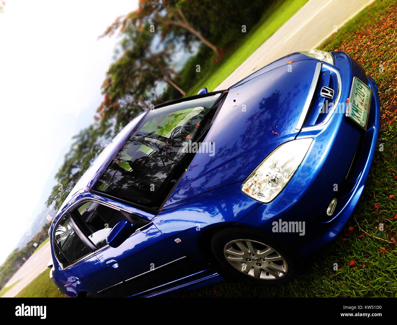 Diese Abbildung zeigt eine blaue Honda Civic Limousine mit dem Kennzeichen XMF 209. Der Honda Civic ist ein beliebtes Kompaktfahrzeug, das für seine Effizienz und Langlebigkeit im täglichen Transport bekannt ist. Stockfoto