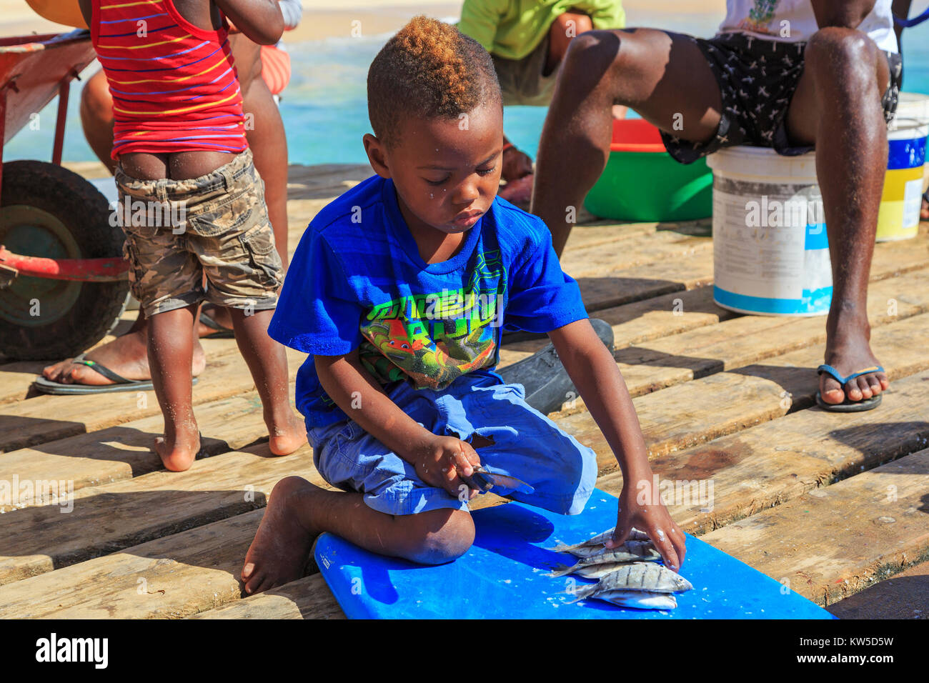 Junge Vorbereitung der Fisch, den er auf dem Pier in Santa Maria, Sal, Salina, Kap Verde, Afrika gefangen hat. Stockfoto