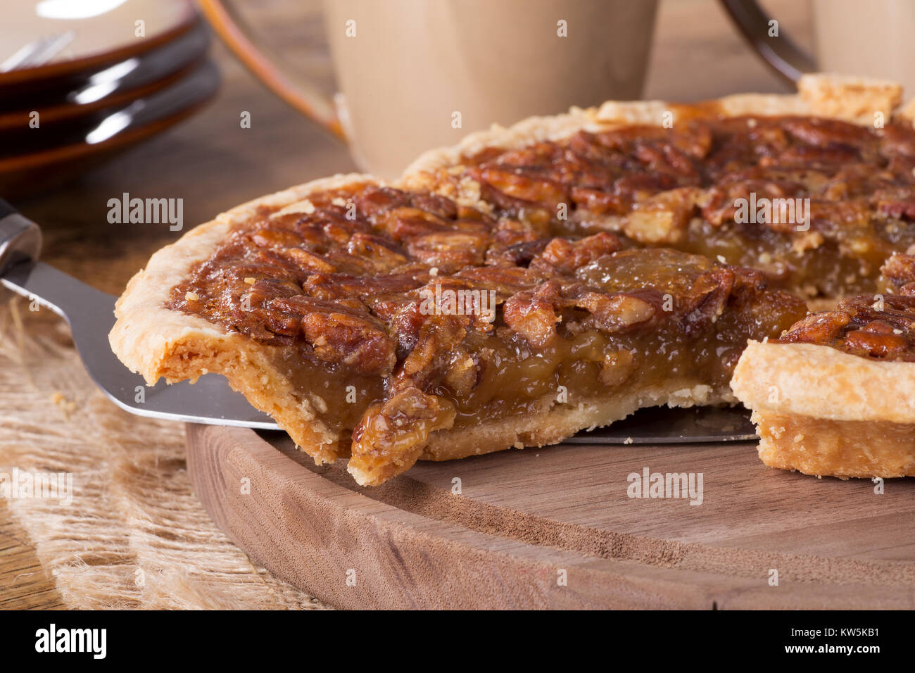 Nahaufnahme einer Scheibe von Pecan Pie auf einer hölzernen Platte Stockfoto