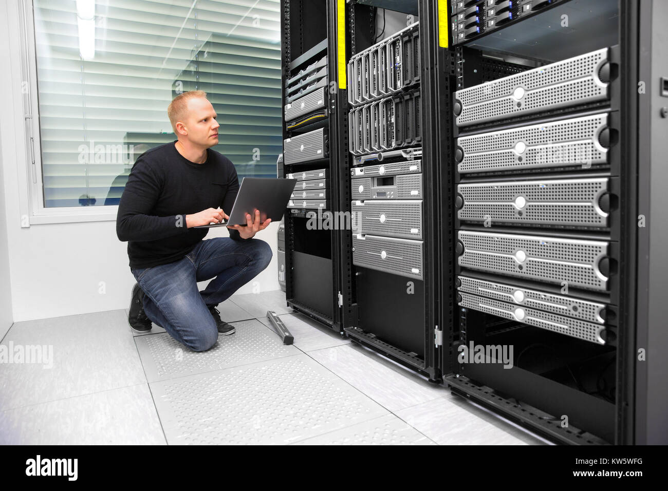 Berater mit Laptop während der Überwachung von Servern im Rechenzentrum Stockfoto