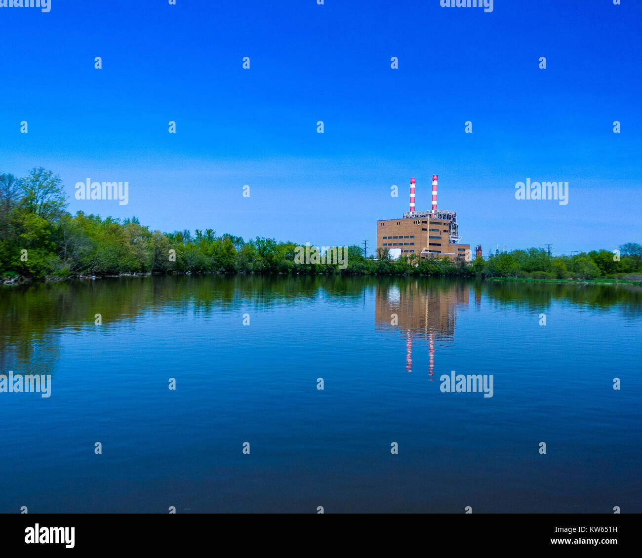 Ein Bild von einem Kraftwerk neben einem Fluss. Das ist ein Bild für die Menschheit die Natur auswirken. Dies war im Hochsommer vom Bug eines Bootes. Stockfoto