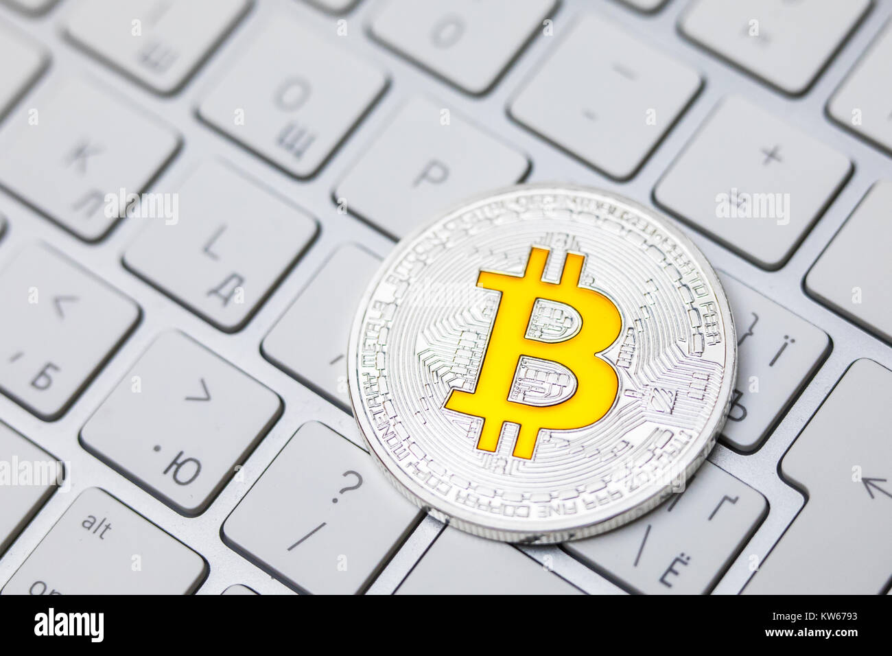 Kryptowährung physisches Silber Bitcoin Münze mit gelben b Zeichen auf der  Tastatur Stockfotografie - Alamy