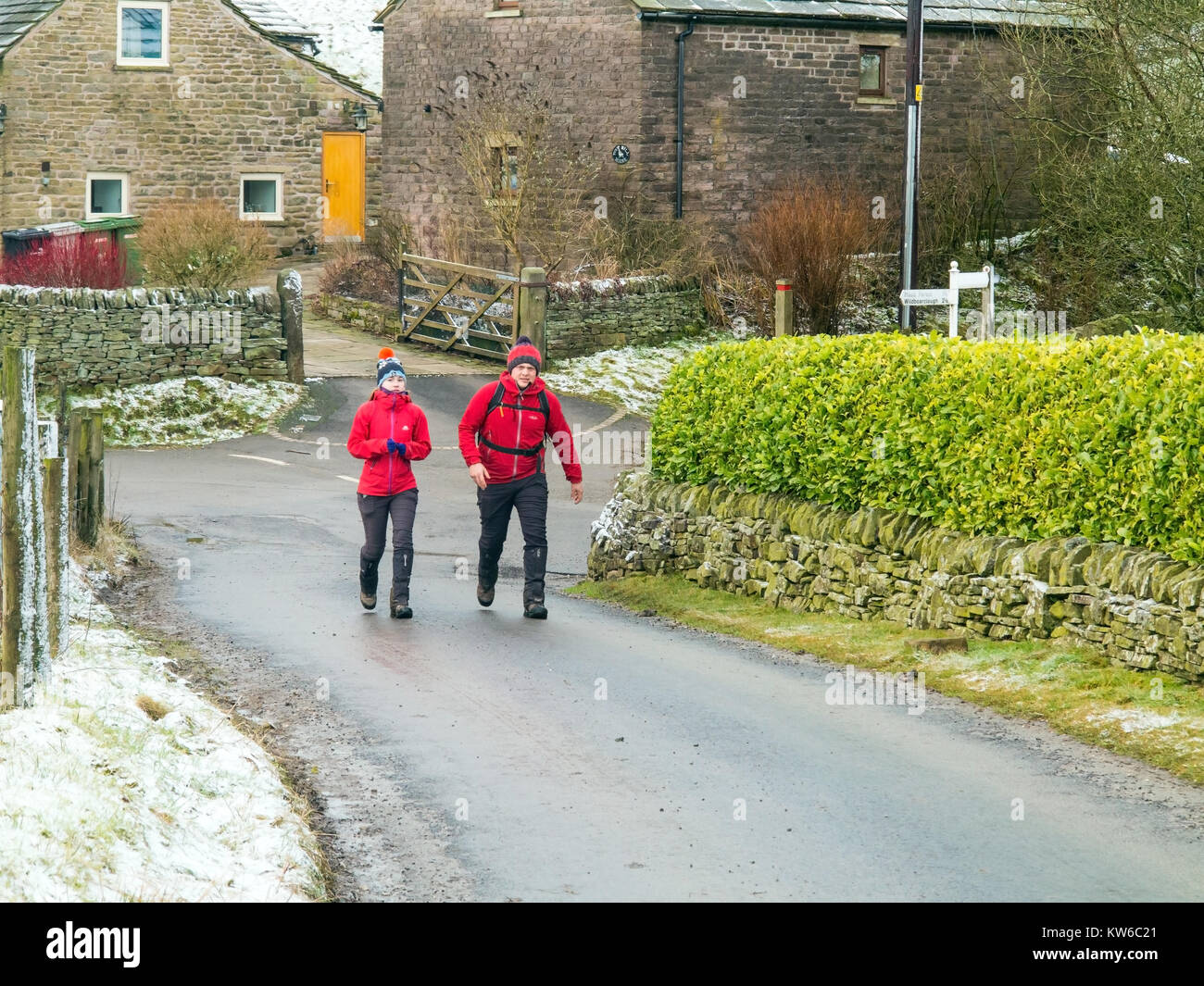 Anzeigen von Mann und Frau zu Fuß im englischen Peak District im Schnee im Winter in der Nähe von Cheshire Wildboarclough Stockfoto