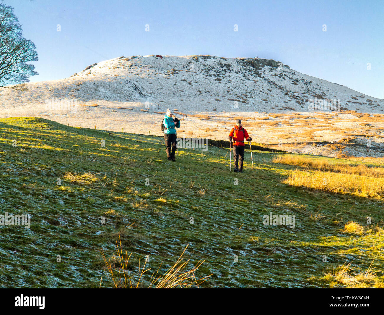 Mann und Frau Wandern im Schnee am Fuß des Hügels Shutlingsloe Wildboarclough Peak District der 3. höchsten Punkt in Cheshire Stockfoto