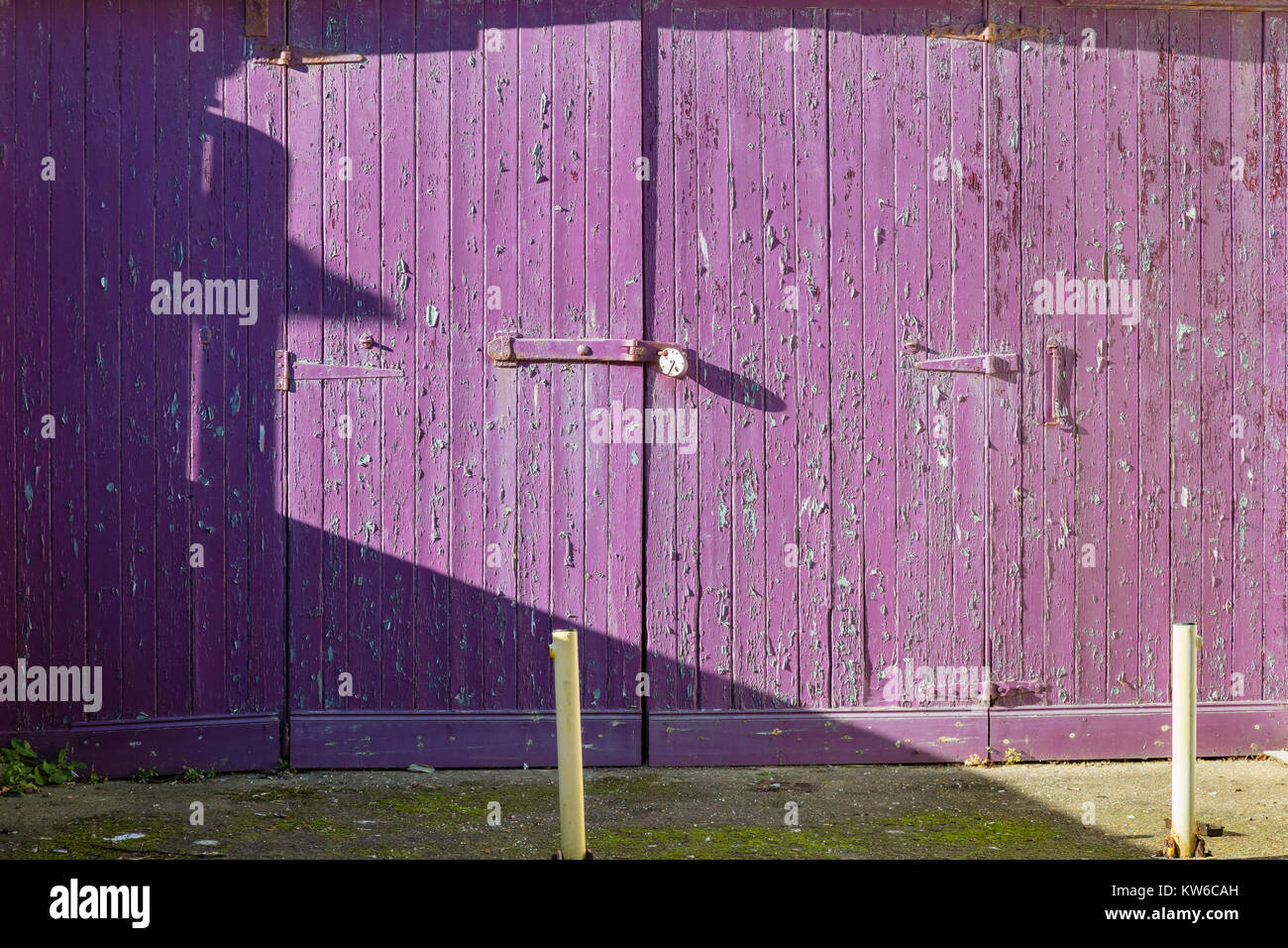 Holz Garagentor mit Peeling violette Farbe in Bexhill-on-Sea, East Sussex, Großbritannien Stockfoto