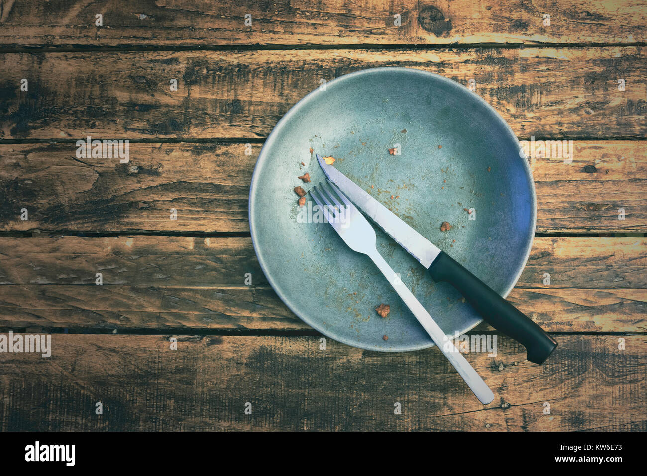 Top View oder flach Bild eines schmutzigen Teller, nachdem sie den Teller auf einem grungy hölzernen Tisch gegessen. Essen Konzept. Stockfoto