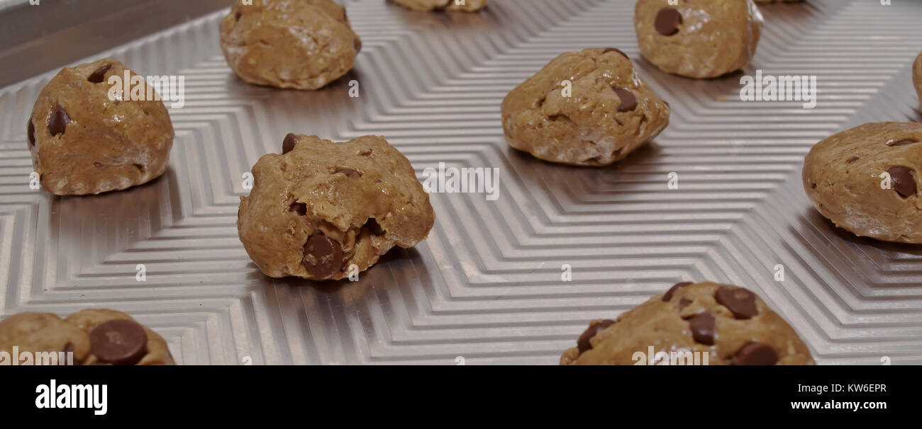 Eine Nahaufnahme von raw Chocolate Chip Cookie Dough, rollte in die Kugeln auf ein Backblech Stockfoto