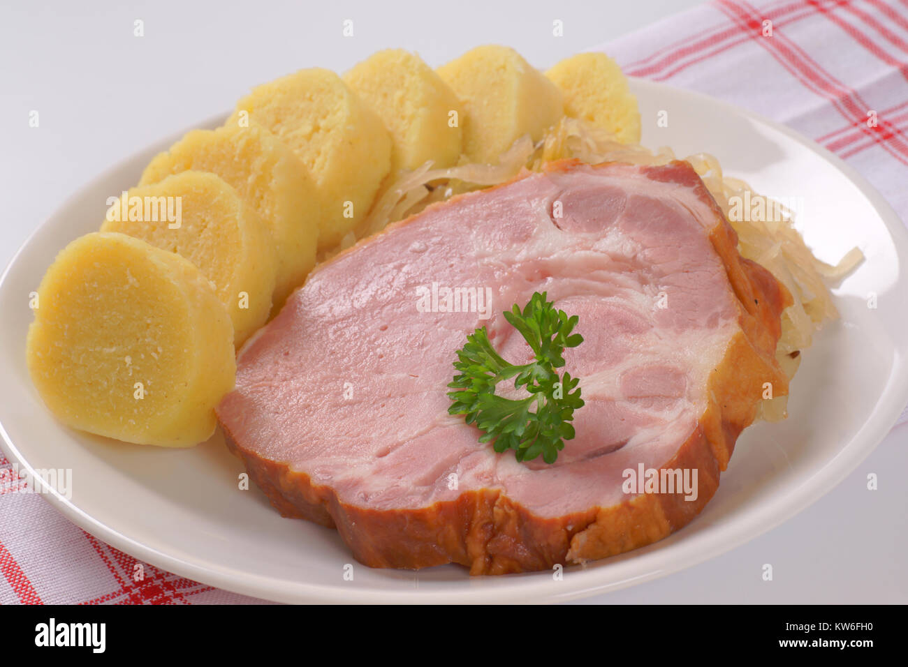 Platte von geräuchertem Schweinefleisch Hals mit Klößen und Sauerkraut - Nahaufnahme Stockfoto