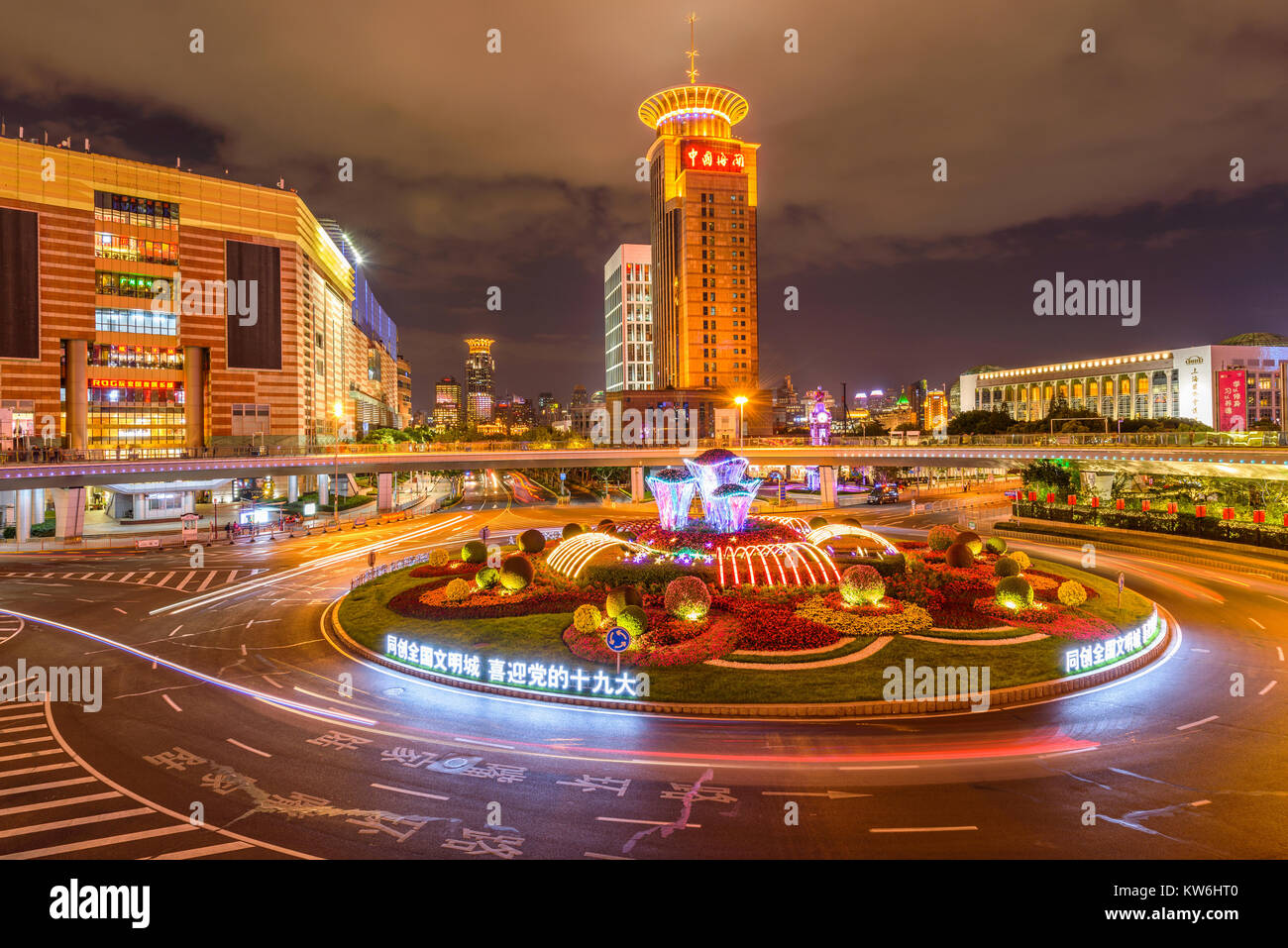 Nacht in Lujiazui Kreisverkehr - Die grüne Insel in der Mitte des Lujiazui Verkehr Kreis ist mit bunten Lichtern und frischen Blumen geschmückt. Shanghai Stockfoto