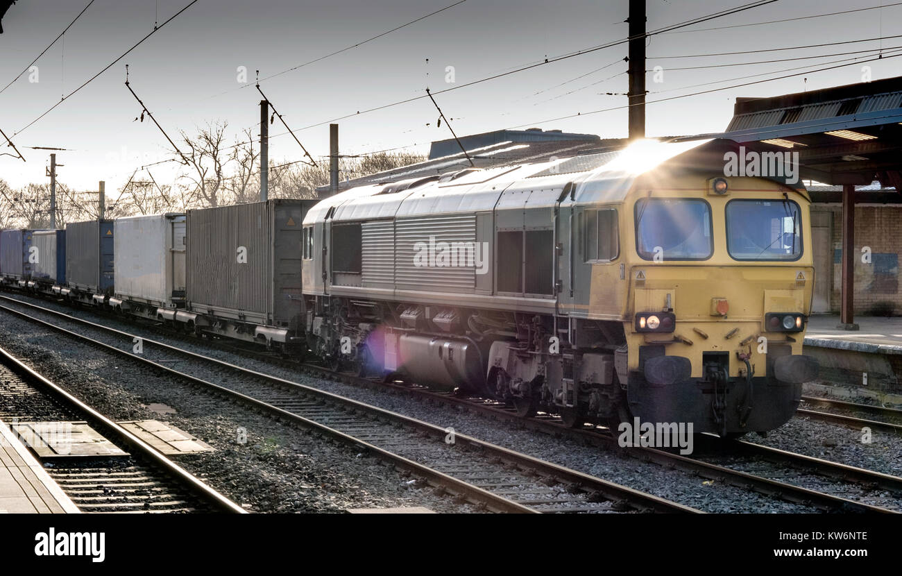 Güterzug an der Plattform, Sonnenlicht reflektiert der Glasdach, das lensflare Stockfoto