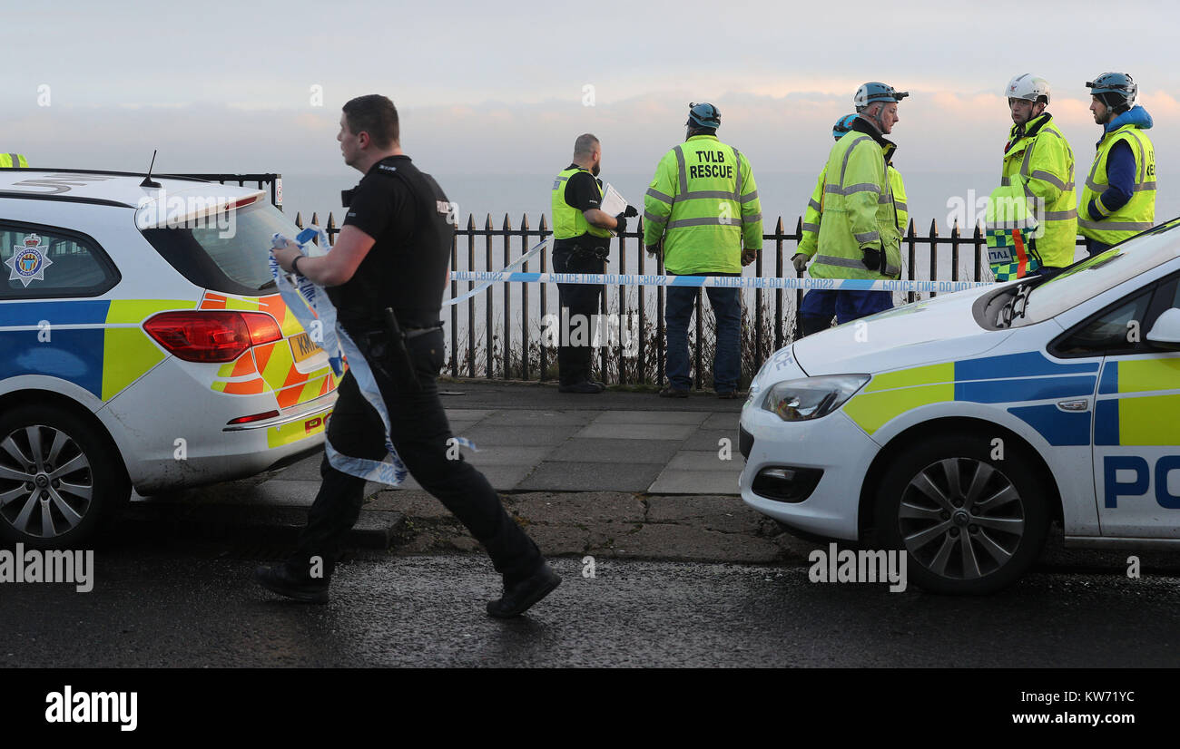 Mitglieder der Rettungsdienste nehmen an der Szene in Browns Bay an der nordöstlichen Küste in der Nähe von cullercoats nach einem Körper auf den Felsen am Meer gefunden wurde. Stockfoto