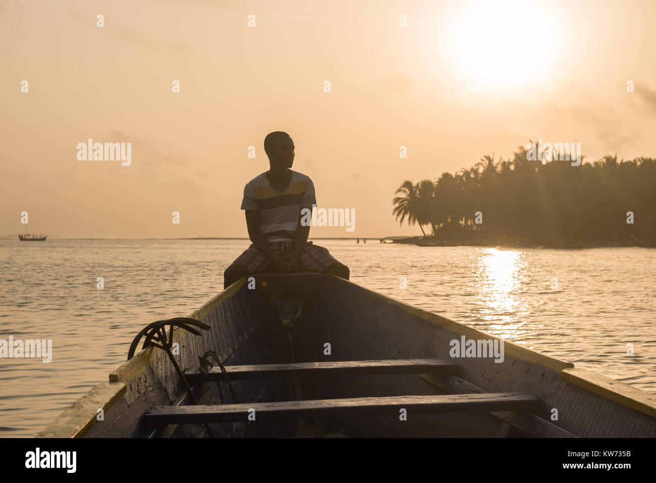 Ein Mann sitzt in einem Boot auf eine Reise auf der Volta River, Ada Foah, Greater Accra Region, Ghana, Afrika Stockfoto