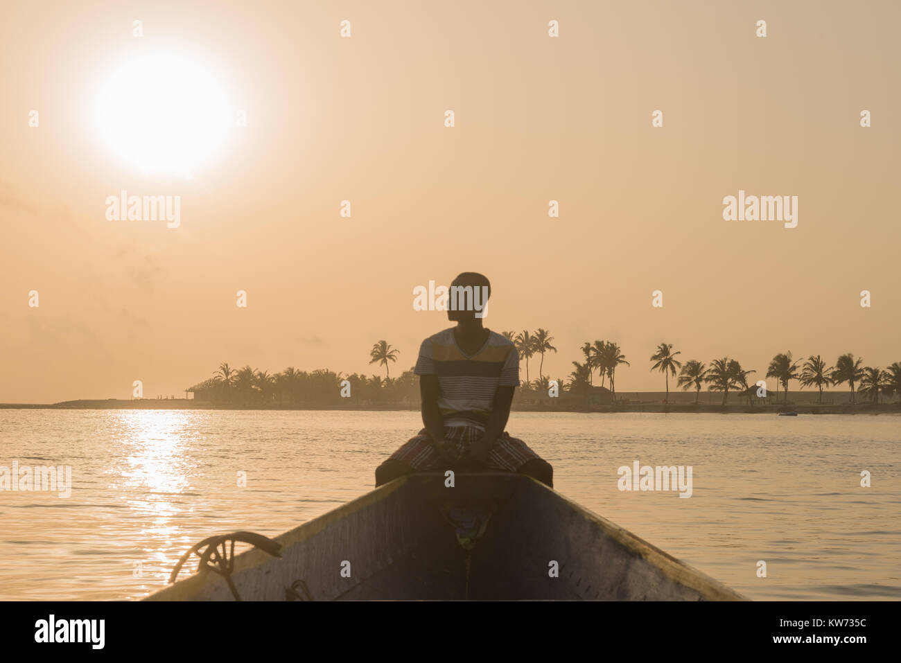 Ein Mann sitzt in einem Boot auf eine Reise auf der Volta River, Ada Foah, Greater Accra Region, Ghana, Afrika Stockfoto