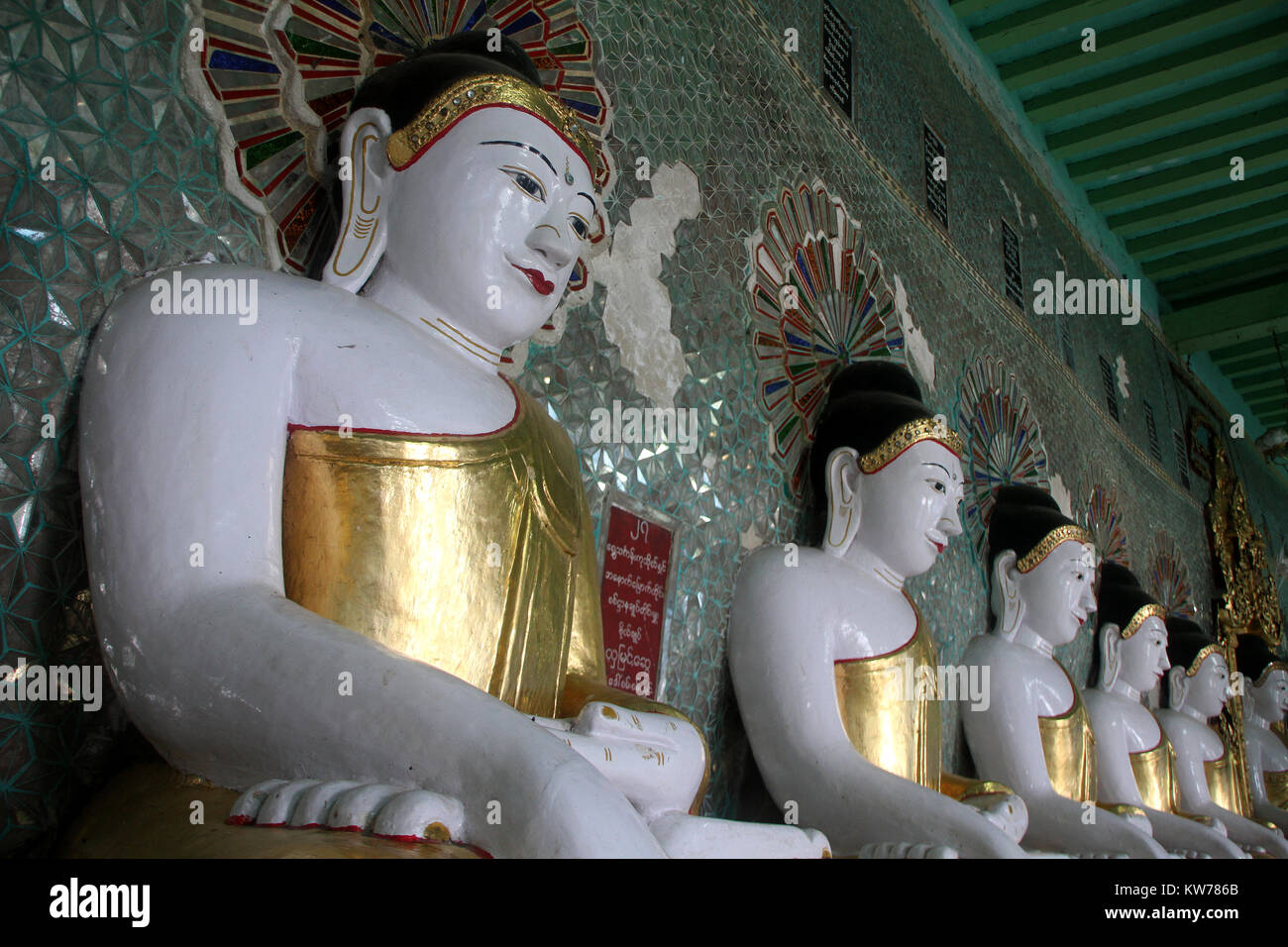 Lange Reihe von Buddhas im Korridor der Tempel auf dem Sagaing Hill in der Nähe von Mandalay, Myanmar Stockfoto