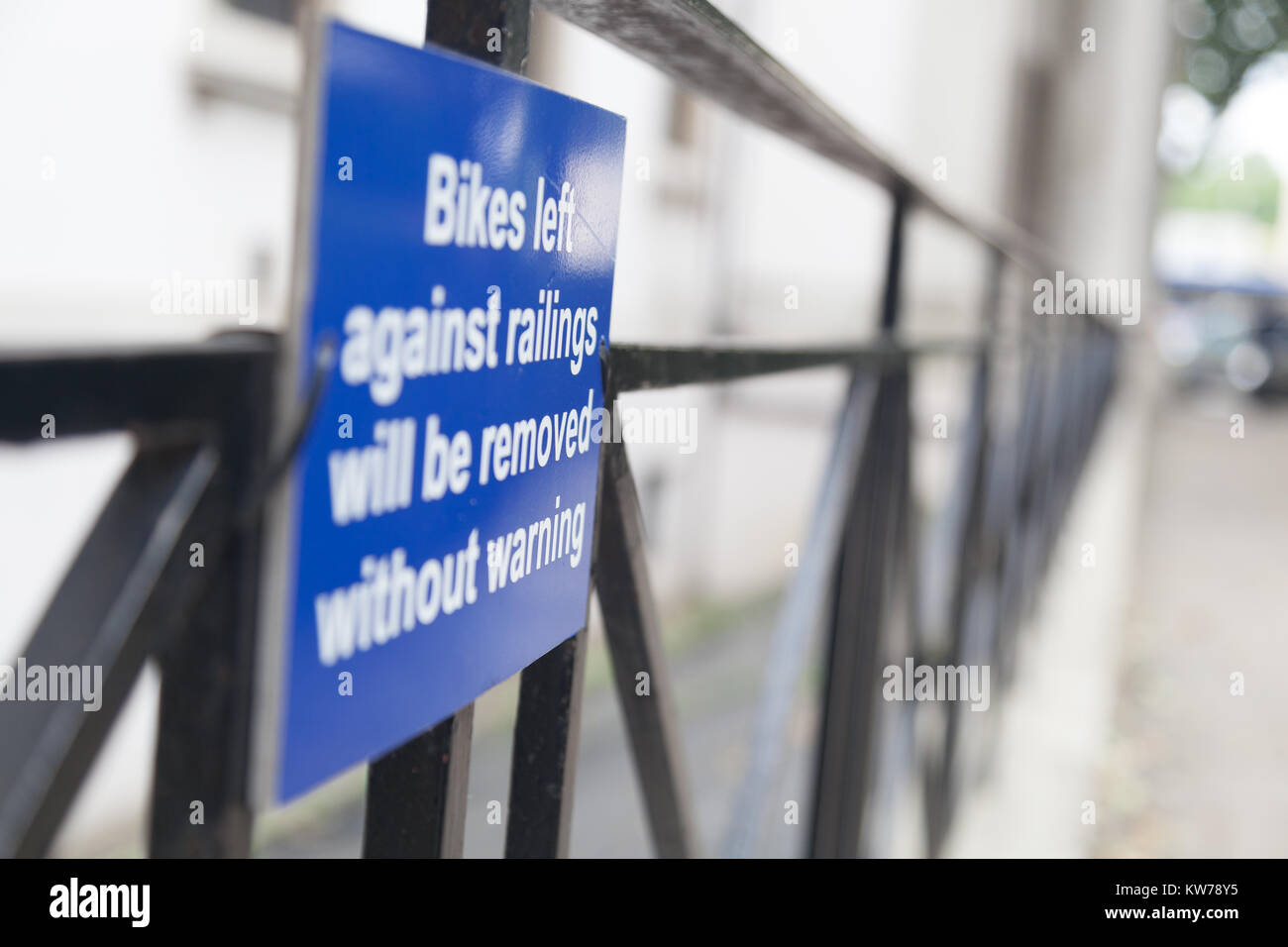 Schild "Leihfahrräder gegen Geländer links ohne Warnung" entfernt werden. Stockfoto